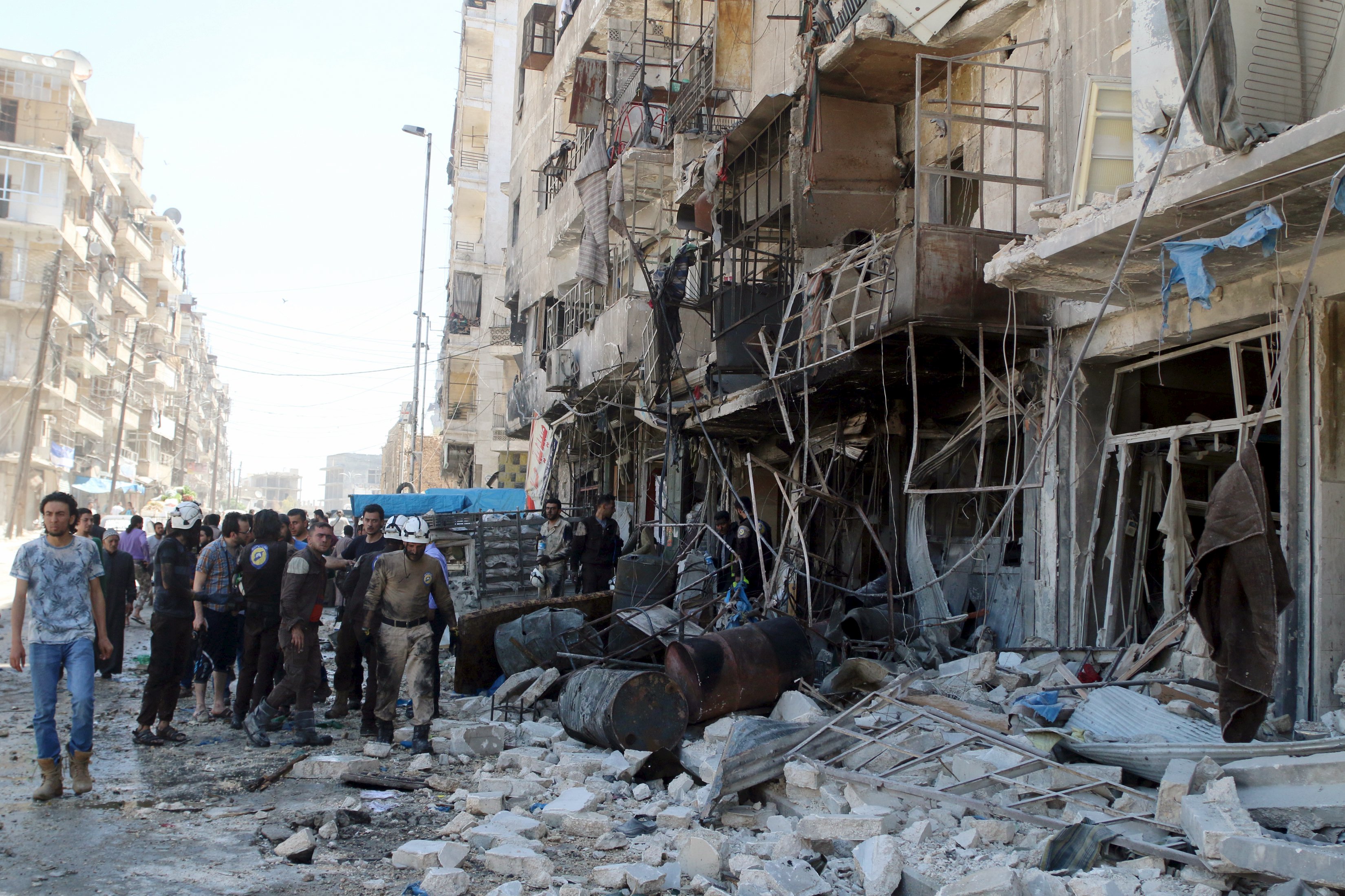 Residents and civil defence members inspect a damaged building after an airstrike on the rebel-held Tariq al-Bab neighbourhood of Aleppo