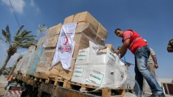 Palestinians check Turkish aid shipments upon arrival in the Gaza Strip at Kerem Shalom crossing between Israel and southern Gaza Strip