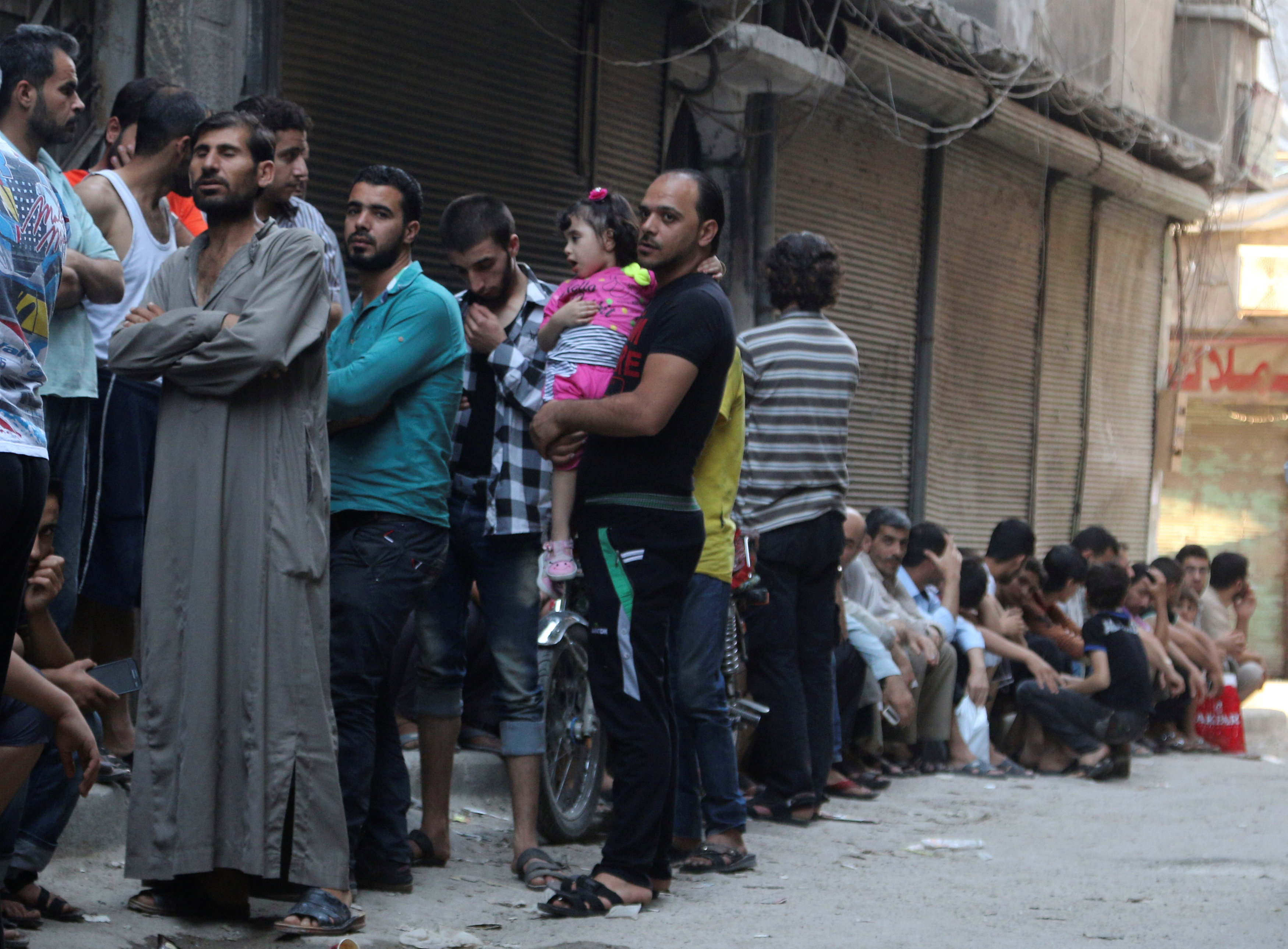 People queue for bread in the rebel held al-Shaar neighbourhood of Aleppo