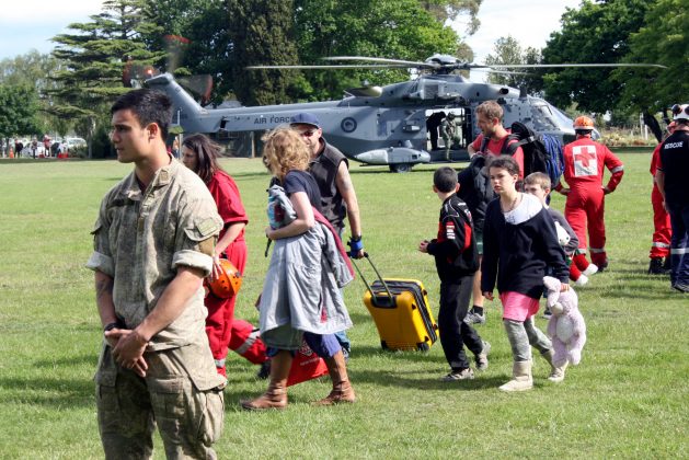 Evacuees formerly stranded in the earthquake-affected town of Kaikoura walk away from the New Zealand Air Force helicopter that brought them to the town of Woodend, near Christchurch, New Zealand,