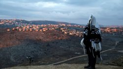 A Jewish man covered in a prayer shawl, prays in the Jewish settler outpost of Amona in the West Bank