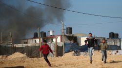 Palestinians run from air strike