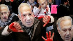 FILE PHOTO: Anti-Israel demonstrators led by the protest group Code Pink wear masks of Israeli Prime Benjamin Netanyahu as they sit at the entrance to the American Israel Public Affairs Committee (AIPAC) policy conference at the Washington Convention Center in Washington, March 1, 2015. REUTERS/Jonathan Ernst/File Photo