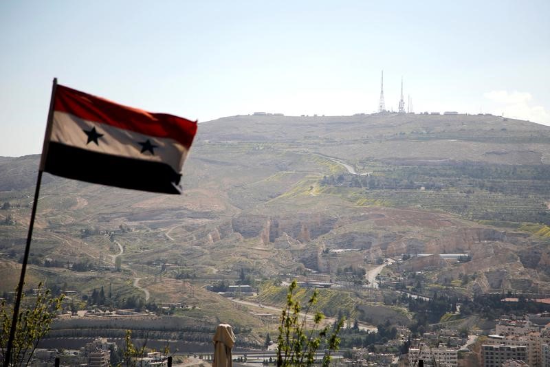 A Syrian national flag flutters as Qasioun mountain is seen in the background from Damascus, Syria April 7, 2017. REUTERS/Omar Sanadiki