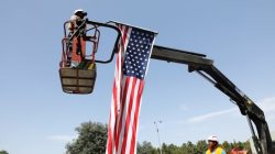 A labourer stands on a crane as he hangs an American flag to a street post, in preparation for the upcoming visit of U.S. President Donald Trump to Israel, in Jerusalem May 18, 2017. REUTERS/Ronen Zvulun