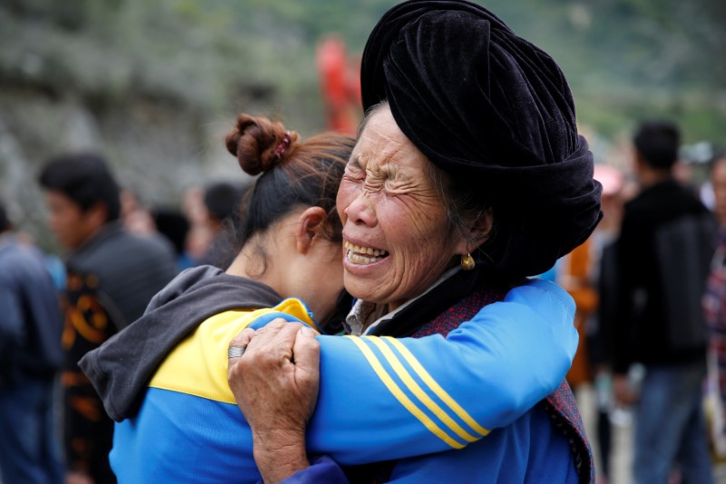 Relatives of victims react at the site of a landslide in the village of Xinmo, Mao County, Sichuan Province, China June 26, 2017.