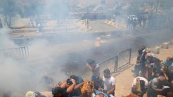Palestinians react following tear gas that was shot by Israeli forces after Friday prayer on a street outside Jerusalem's Old city July 21, 2017. REUTERS/Ammar Awad