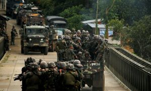 FILE PHOTO: Philippines army soldiers ride in trucks into the fighting zone as government troops continue their assault against insurgents from the Maute group in Marawi City, Philippines June 28, 2017. REUTERS/Jorge Silva