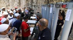 Palestinians stand in front of Israeli policemen and newly installed metal detectors at an entrance to the compound known to Muslims as Noble Sanctuary and to Jews as Temple Mount, in Jerusalem's Old City July 16, 2017.