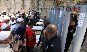 Palestinians stand in front of Israeli policemen and newly installed metal detectors at an entrance to the compound known to Muslims as Noble Sanctuary and to Jews as Temple Mount, in Jerusalem's Old City July 16, 2017.