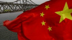 : A Chinese flag is seen in front of the Friendship bridge over the Yalu River connecting the North Korean town of Sinuiju and Dandong in China's Liaoning Province on April 1, 2017.