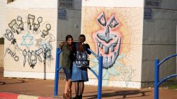 Schoolgirls stand next to bus stop bomb shelters in the southern Israeli city of Sderot, close to the Israeli border with the Gaza Strip January 8, 2018.