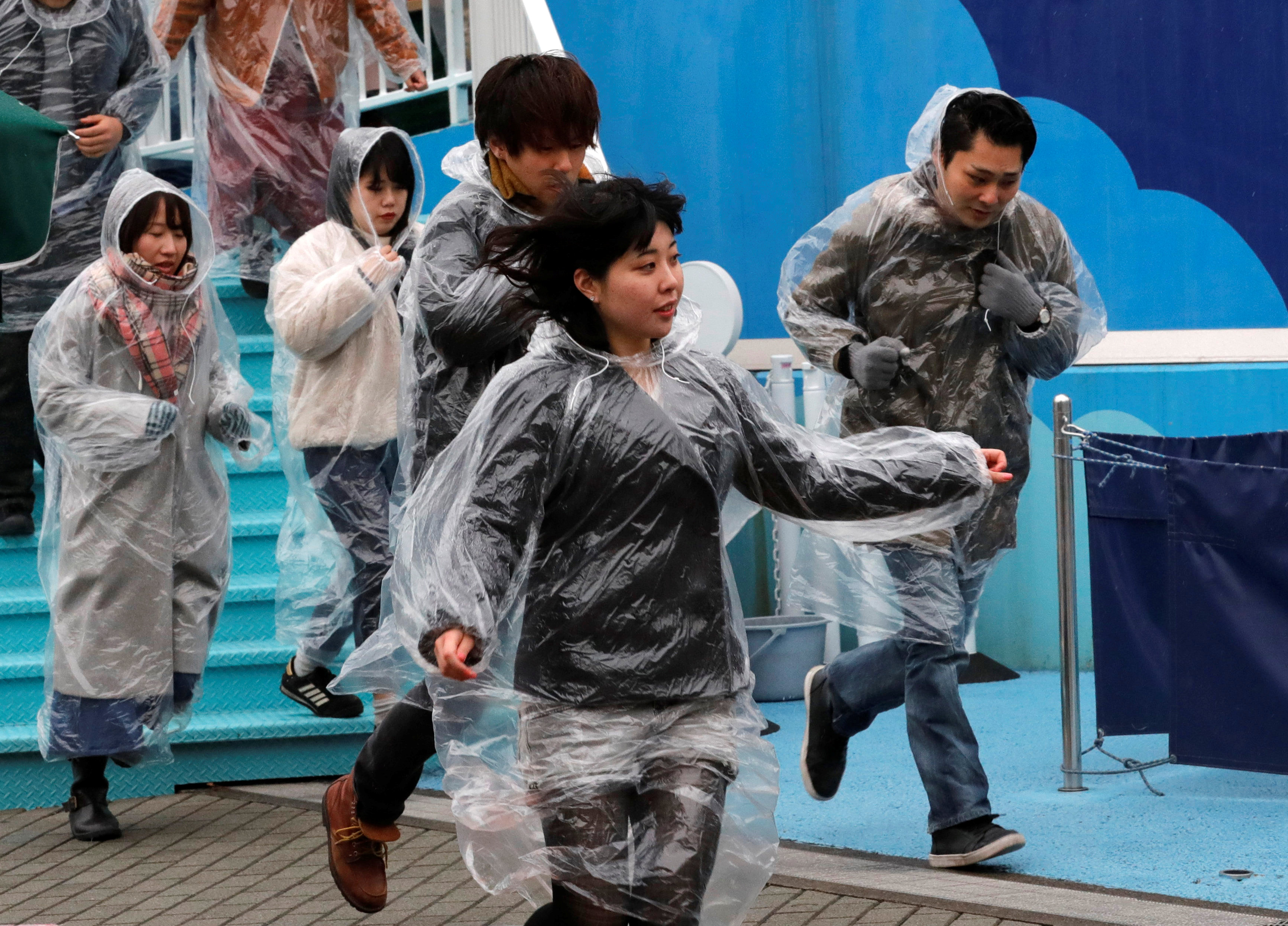 Participants run during an anti-missile evacuation drill at the Tokyo Dome City amusement park in Tokyo, Japan January 22, 2018.