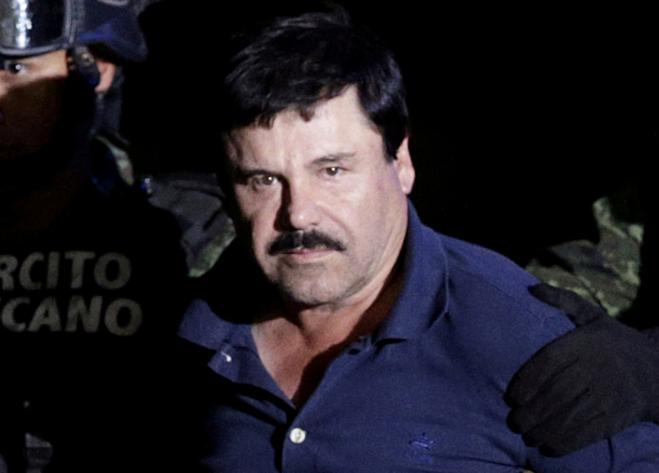 Recaptured drug lord Joaquin "El Chapo" Guzman is escorted by soldiers at the hangar belonging to the office of the Attorney General in Mexico City, Mexico January 8, 2016