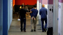 FILE PHOTO: A U.S.-Israeli teen arrested in Israel on suspicion of making bomb threats against Jewish community centres in the United States, Australia and New Zealand over the past three months, is escorted by security personnel following his remand hearing at Magistrate's Court in Rishon Lezion, Israel March 23, 2017. REUTERS/Baz Ratner/File Photo