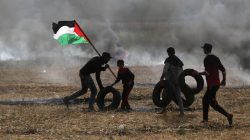 Palestinian protesters carry tires to burn them during clashes with Israeli troops at Israel-Gaza border, in the southern Gaza Strip April 5, 2018. REUTERS/Ibraheem Abu Mustafa