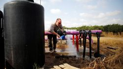 A farmer tends to a water faucet in a field in Kibbutz Nahal Oz, near the Gaza Strip border, Israel April 8, 2018. REUTERS/Amir Cohen