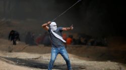 A demonstrator gestures as he hurls stones during clashes with Israeli troops at a protest at the Israel-Gaza border where Palestinians demand the right to return to their homeland, east of Gaza City April 20, 2018. REUTERS/Mohammed Salem