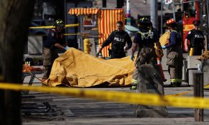 Firemen cover a victim of an incident where a van struck multiple people at a major intersection in Toronto's northern suburbs, in Toronto, Ontario, Canada, April 23, 2018. REUTERS/Carlo Allegri
