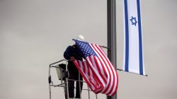 A worker on a crane hangs a U.S. flag next to an Israeli flag, next to the entrance to the U.S. consulate in Jerusalem, May 7, 2018. REUTERS/Ronen Zvulun/File Photo