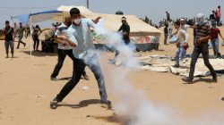 A demonstrator uses a racket to return a tear gas canister fired by Israeli troops during a protest where Palestinians demand the right to return to their homeland, at the Israel-Gaza border in the southern Gaza Strip, May 11, 2018. REUTERS/Ibraheem Abu Mustafa