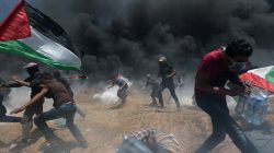 Palestinian demonstrators run for cover from Israeli fire and tear gas during a protest against U.S. embassy move to Jerusalem and ahead of the 70th anniversary of Nakba, at the Israel-Gaza border in the southern Gaza Strip May 14, 2018. REUTERS/Ibraheem Abu Mustafa