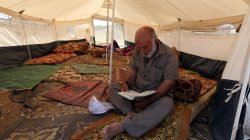 A Palestinian man reads the Koran inside a tent during the holy month of Ramadan, at a protest camp near the Israel-Gaza border in the central Gaza Strip May 17, 2018. REUTERS/Ibraheem Abu Mustafa