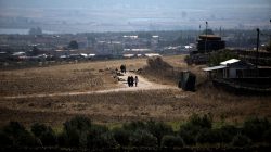 People walk near the Israel-Syria border line as it is seen from the Israeli-occupied Golan Heights, Israel July 7, 2018. REUTERS/Ronen Zvulun