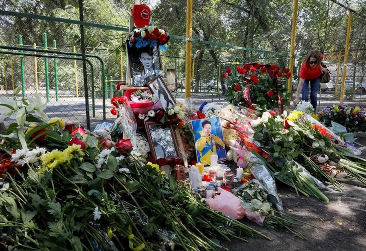 A woman places flowers at the site of the assassination of Kazakhstan's Olympic figure skater Denis Ten in Almaty, Kazakhstan July 20, 2018. REUTERS/Shamil Zhumatov - RC1B8C889C90