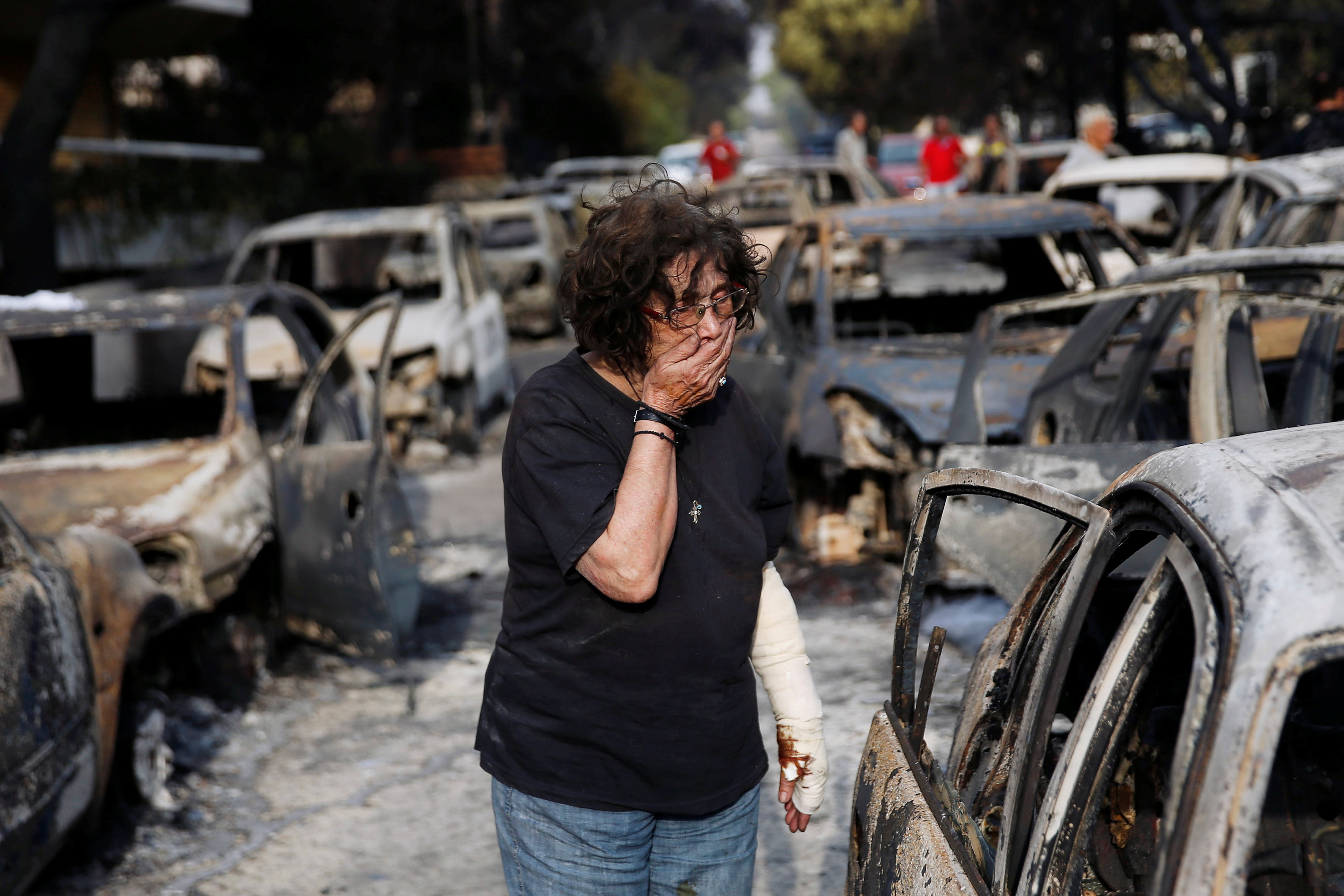 A woman reacts as she tries to find her dog, following a wildfire at the village of Mati, near Athens, Greece July 24, 2018. REUTERS/Costas Baltas