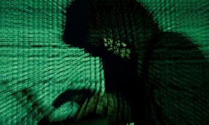 A man holds a laptop computer as cyber code is projected on him in this illustration picture taken on May 13, 2017. REUTERS/Kacper Pempel/Illustration