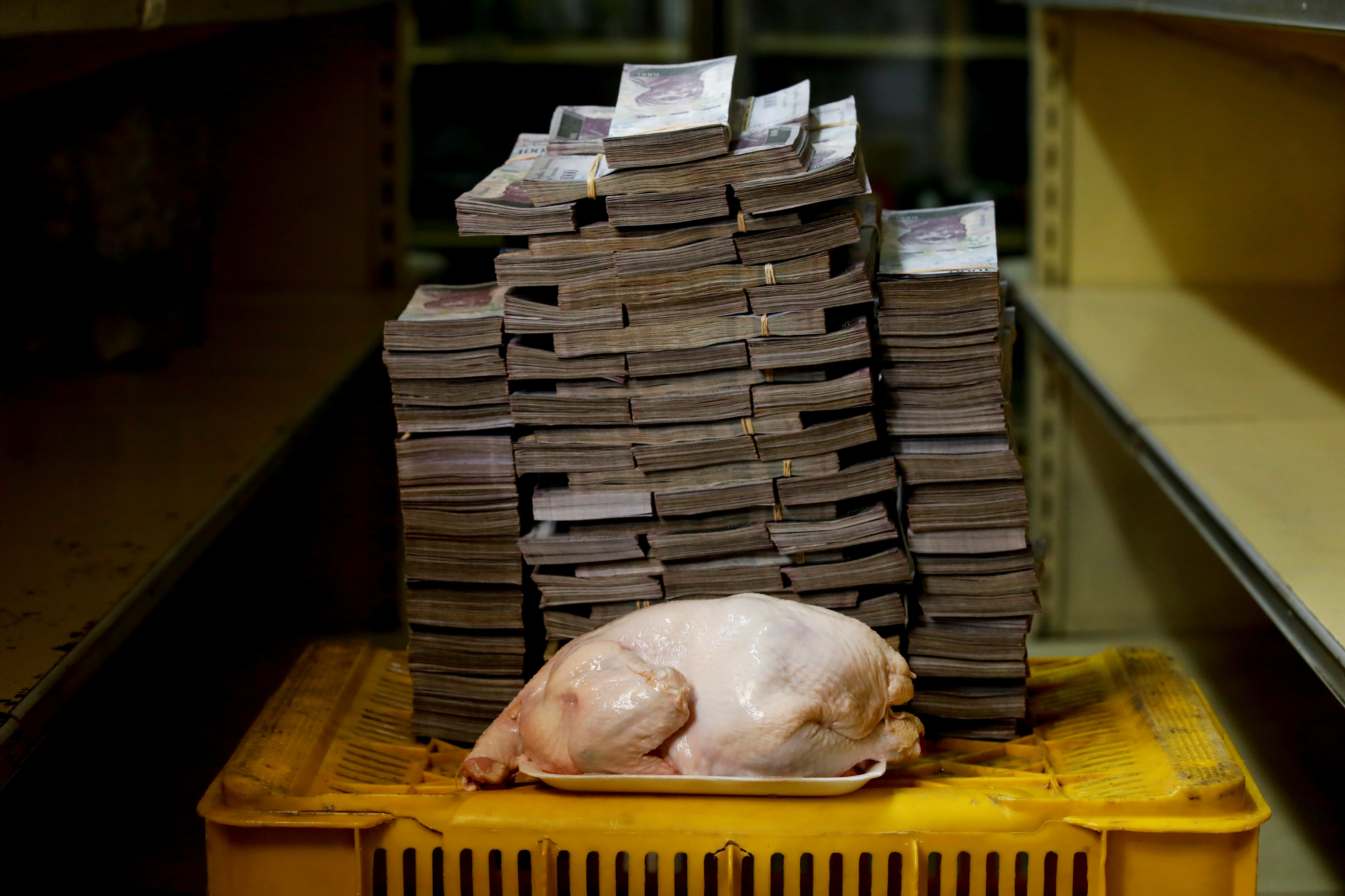 A 2.4 kg chicken is pictured next to 14,600,000 bolivars, its price and the equivalent of 2.22 USD, at a mini-market in Caracas, Venezuela. It was the going price at an informal market in the low-income neighborhood of Catia. REUTERS/Carlos Garcia Rawlins