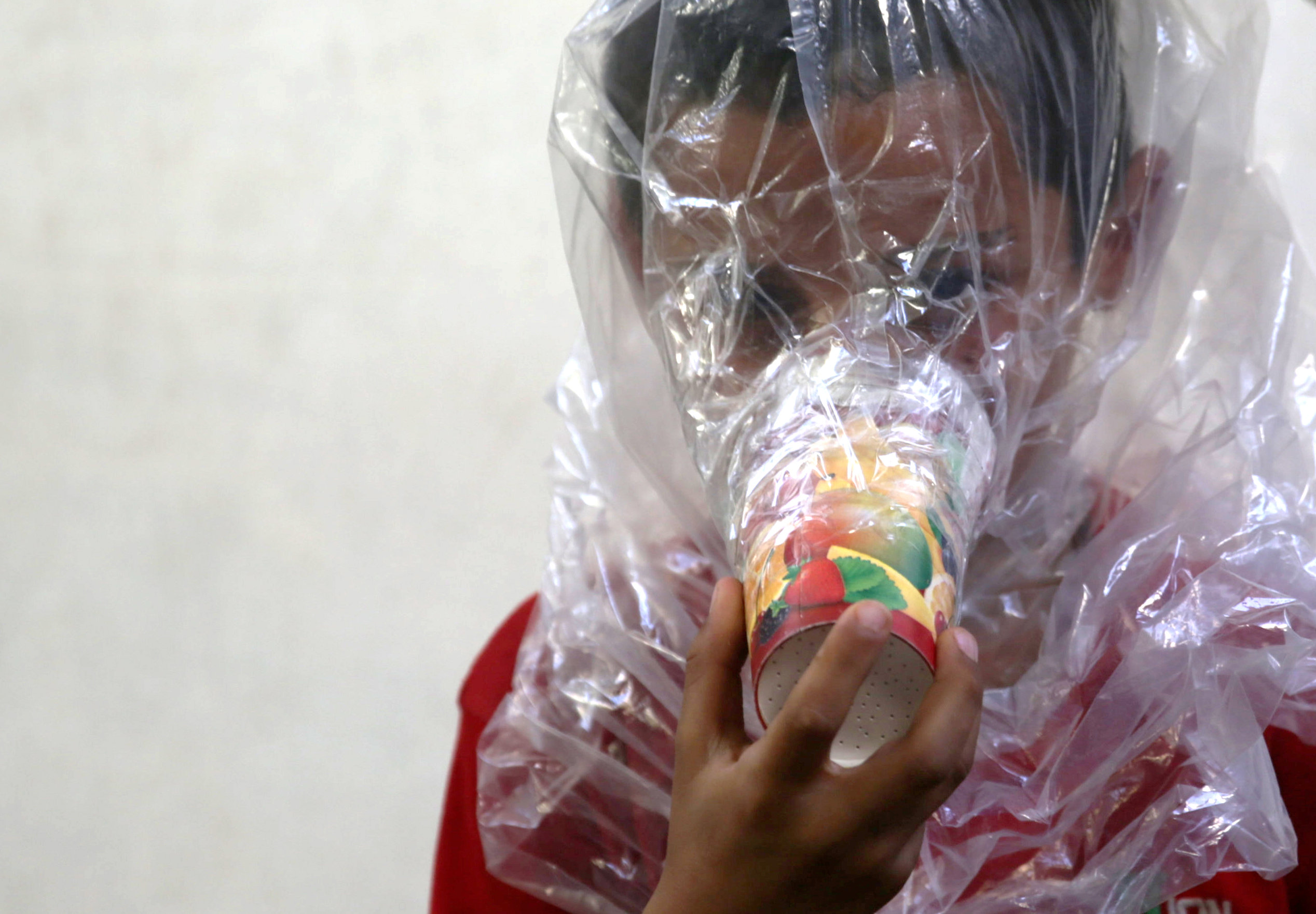 A boy tries on an improvised gas mask in Idlib, Syria September 3, 2018. REUTERS/Khalil Ashawi