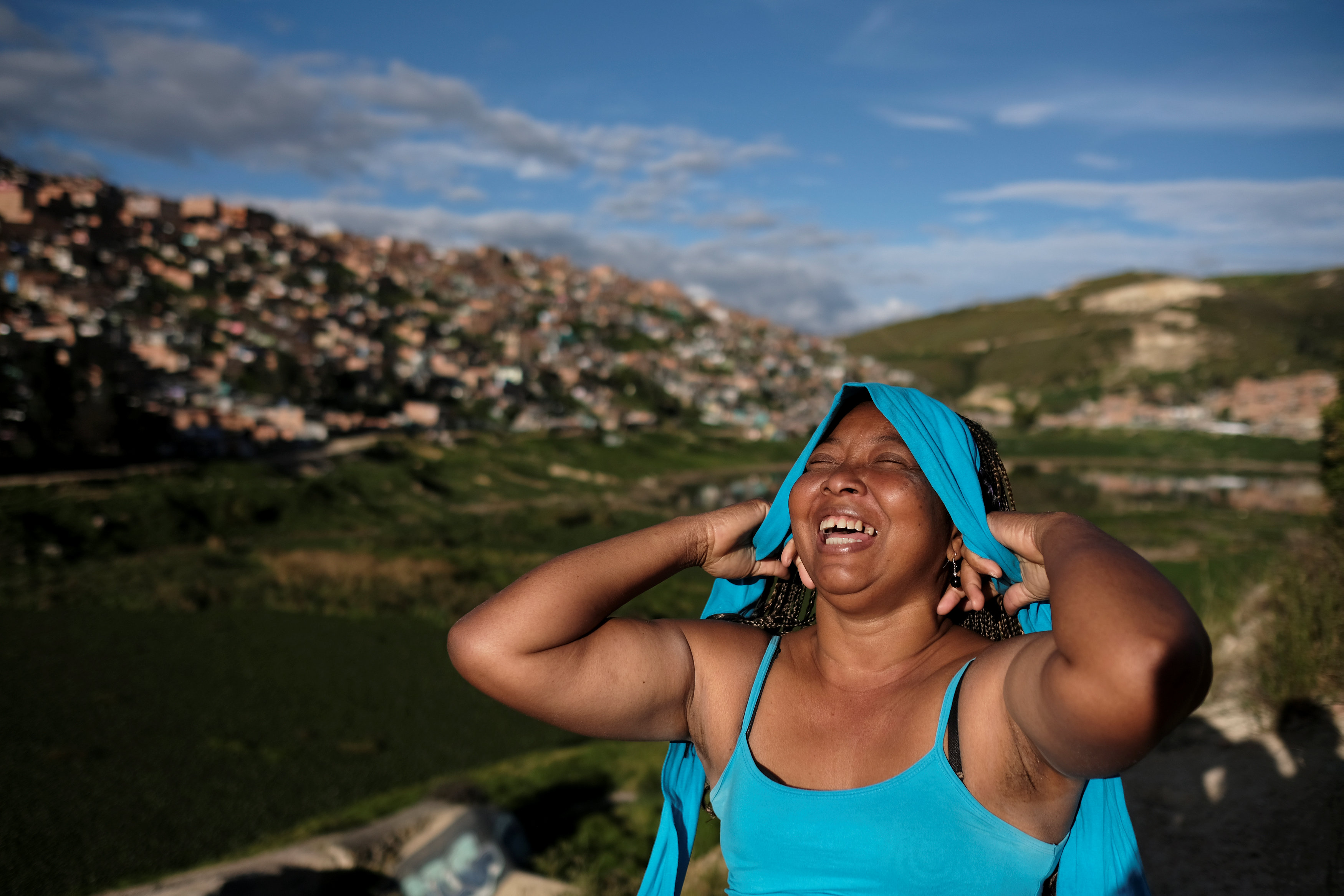 Lina, who said she was raped by dozens of right-wing paramilitary fighters in the Montes de Maria region during the five-decade civil war, laughs as she puts on a hairband in Soacha, on the outskirts of Bogota, Colombia, June 12, 2018. REUTERS/Nacho Doce