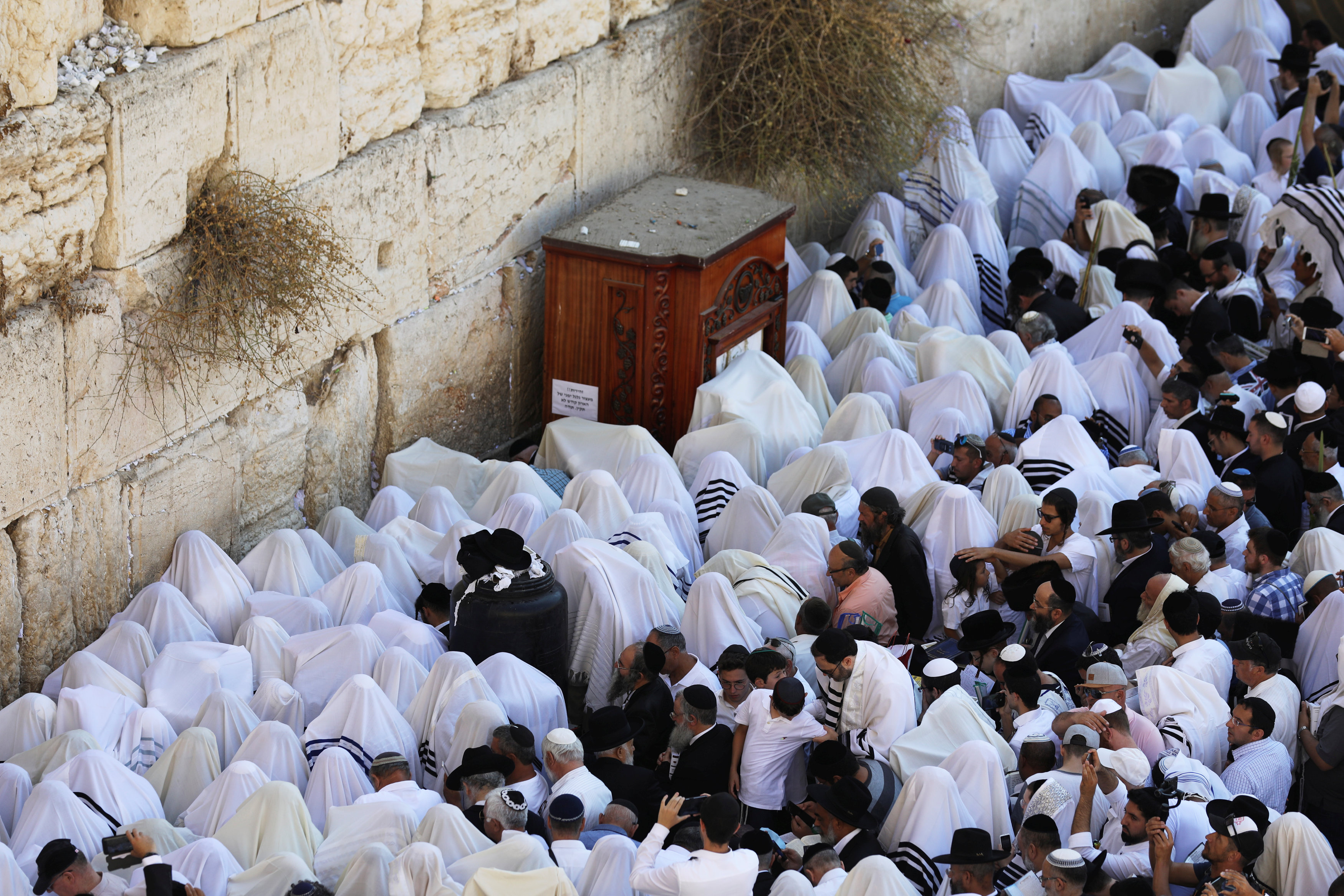 Jewish worshippers, some covered in prayer shawls, pray during a priestly blessing on the Jewish holiday of Sukkot at the Western Wall in Jerusalem's Old City September 26, 2018. REUTERS/Ammar Awad