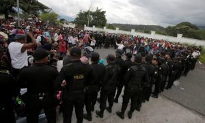 Guatemalan police officers watch as Honduran migrants, part of a caravan trying to reach the U.S., arrive in Esquipulas city in Guatemala, October 15, 2018. REUTERS/Jorge Cabrera