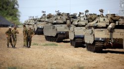 Israeli soldiers speak next to tanks as military armoured vehicles gather in an open area near Israel's border with the Gaza Strip October 18, 2018. REUTERS/Amir Cohen