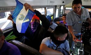 People in a caravan of migrants departing from El Salvador en route to the United States sit on a bus, in San Salvador, El Salvador, November 18, 2018. REUTERS/Jose Cabezas