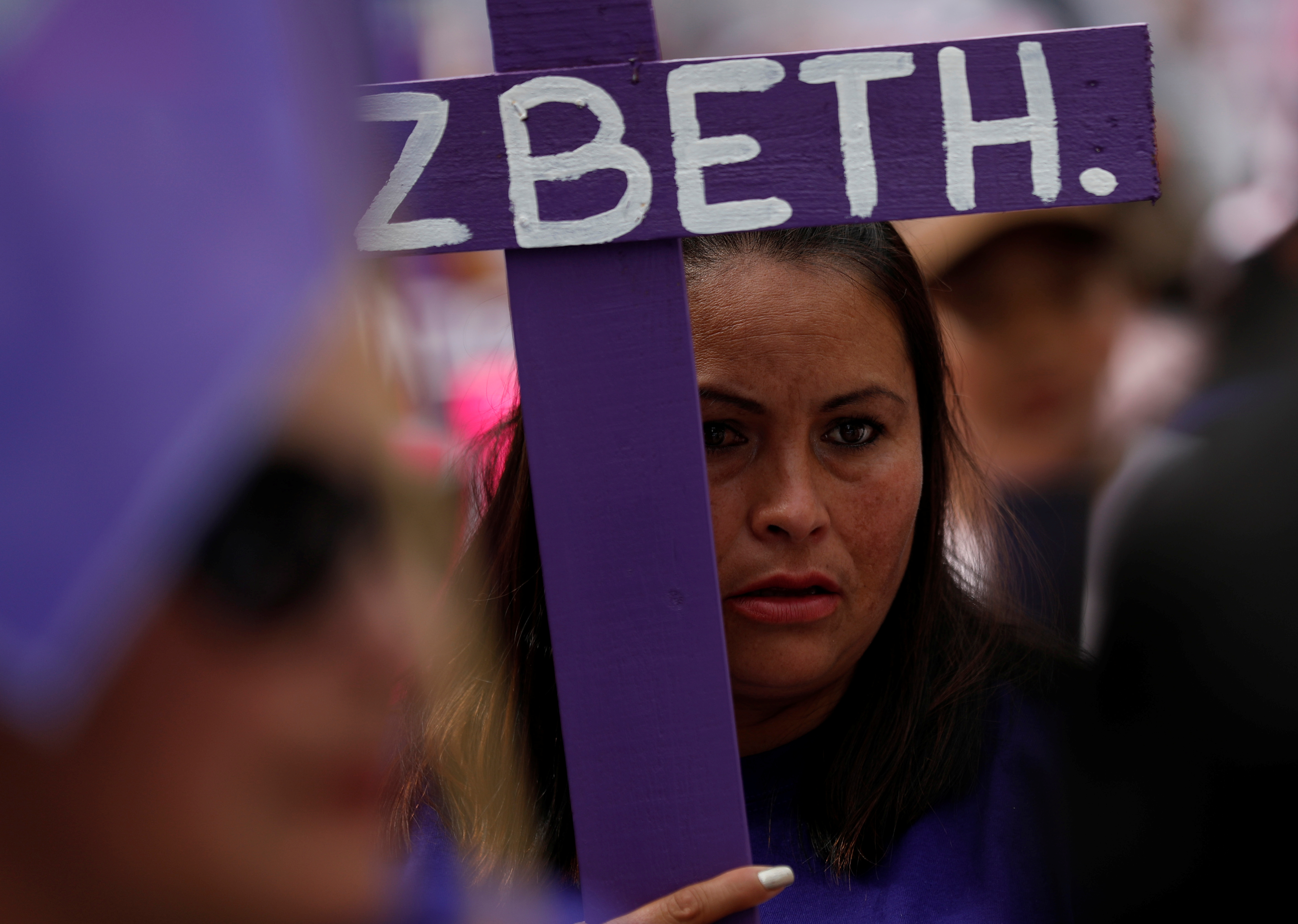 A relative of a woman who was disappeared holds a cross with part of the name of her relative as she takes part in a march for the Elimination of Violence Against Women in Mexico City, Mexico November 3, 2018. REUTERS/Henry Romero