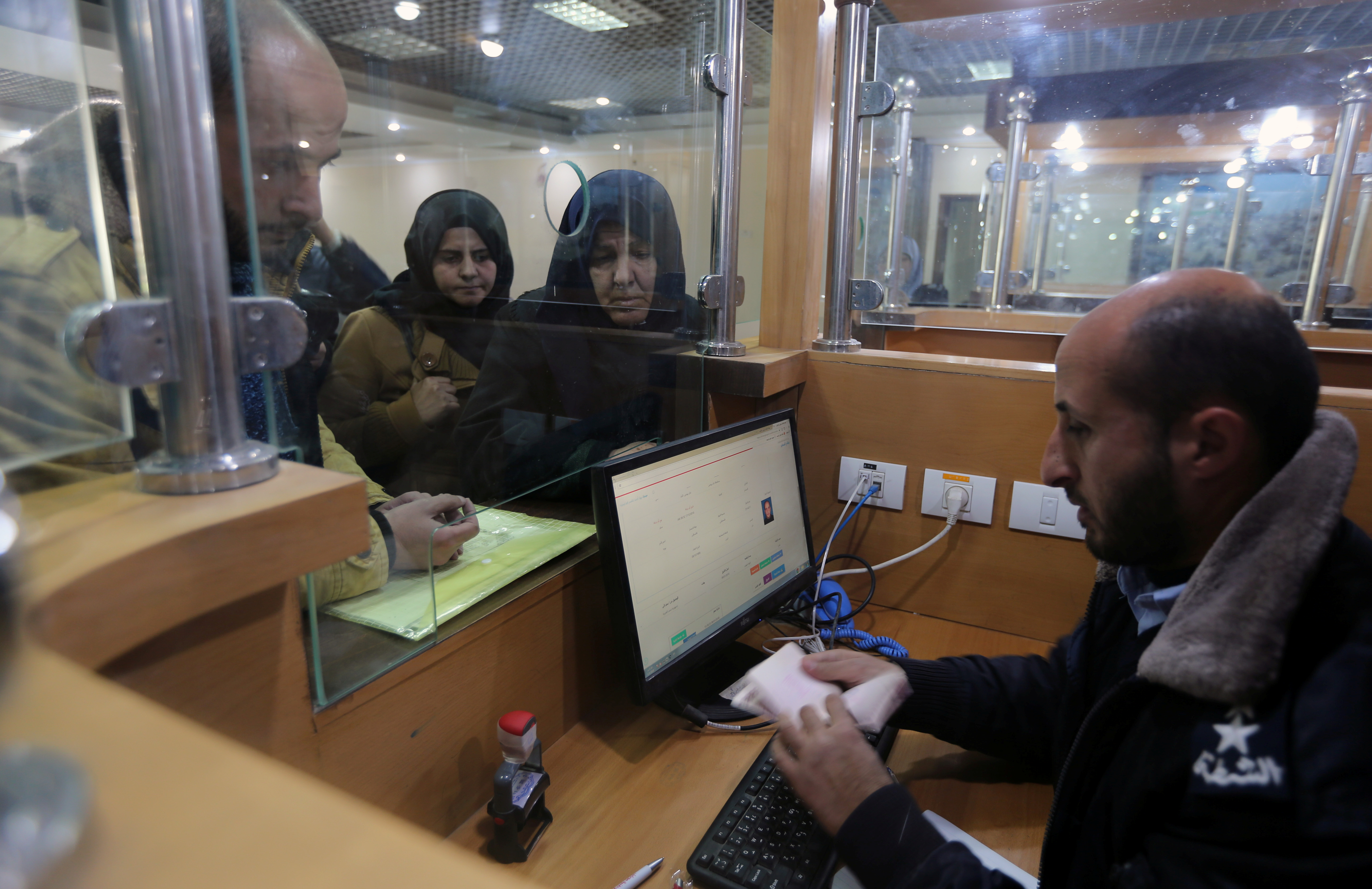 A Palestinian Hamas-hired police officer checks the documents of people upon their return from Egypt, at Rafah border crossing in the southern Gaza Strip January 8, 2019. REUTERS/Ibraheem Abu Mustafa