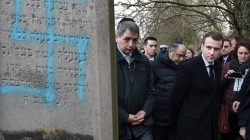 French President Emmanuel Macron looks at a grave vandalised with a swastika during a visit at the Jewish cemetery in Quatzenheim, France February 19, 2019. Frederick Florin/Pool via REUTERS