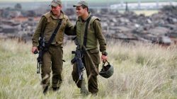 Israeli soldiers stand in a field next to armoured Israeli military vehicles near the border with Gaza, in southern Israel March 27, 2019. REUTERS/Amir Cohen