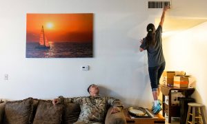 FILE PHOTO: Leanne Bell, 39, checks the air quality of a vent as her husband, Spc. Tevin Mosley, 26, looks on while waiting for a maintenance crew to arrive at the army base housing allocated to the family in Fort Hood, Texas, U.S on May 16, 2019. The family says they began suffering breathing issues, depression, and rashes they attribute to a mold infestation and were forced to vacate the home in March after it was put under quarantine while repairs were made. Despite the repairs, mold can visibly be seen on surfaces throughout the home. REUTERS/Amanda Voisard