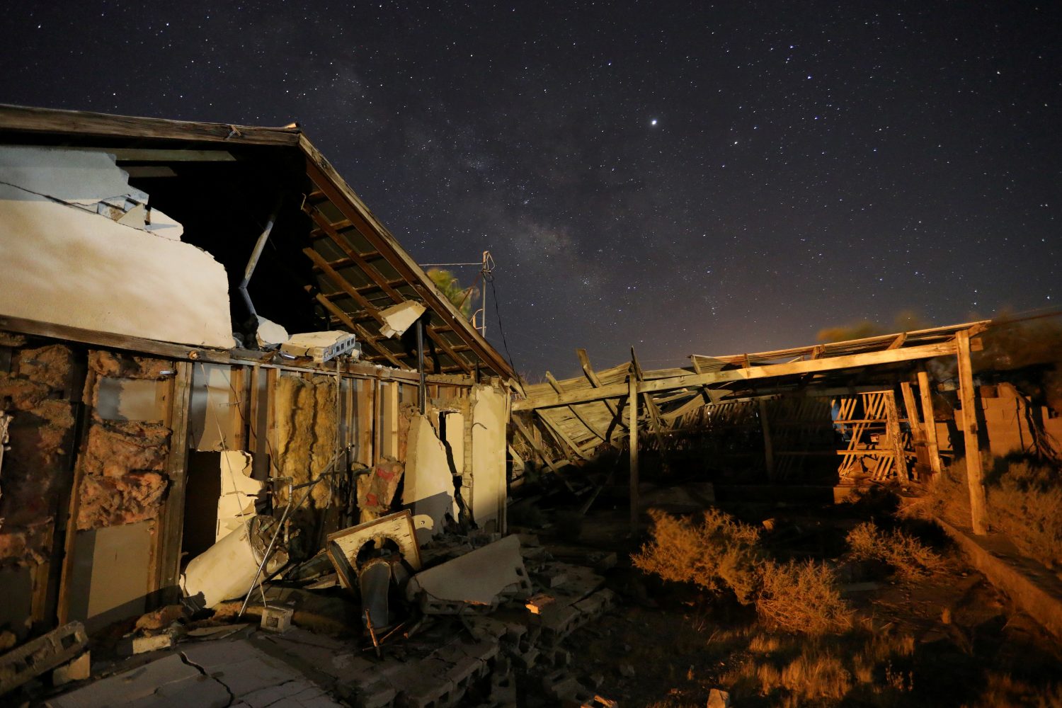 FILE PHOTO - A house left destroyed by a powerful magnitude 7.1 earthquake, triggered by a 6.4 the previous day, is seen at night near the epicenter in Trona, California, U.S., July 6, 2019. REUTERS/David McNew