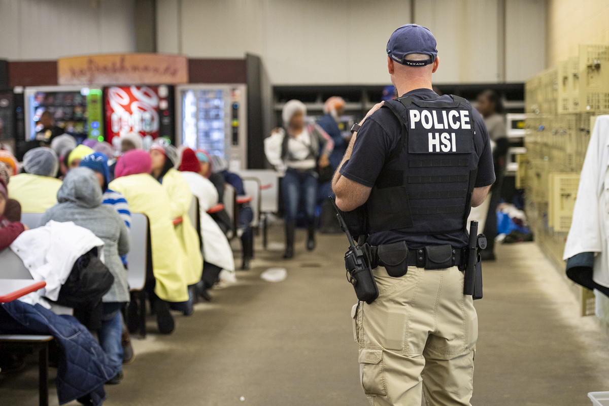 FILE PHOTO: Homeland Security Investigations (HSI) officers from Immigration and Customs Enforcement (ICE) look on after executing search warrants and making arrests at an agricultural processing facility in Canton, Mississippi, U.S. in this August 7, 2019 handout photo. Immigration and Customs Enforcement/Handout via REUTERS/File Photo