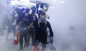 Protesters fire nitrogen extinguishers during a stand off at Yuen Long MTR station, the scene of an attack by suspected triad gang members a month ago, in Yuen Long, New Territories, Hong Kong, China August 21, 2019. REUTERS/Thomas Peter