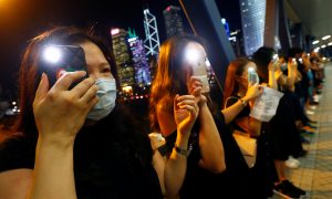 Protesters light up their smartphones as they form a human chain during a rally to call for political reforms in Hong Kong's Central district, China, August 23, 2019. REUTERS/Kai Pfaffenbach